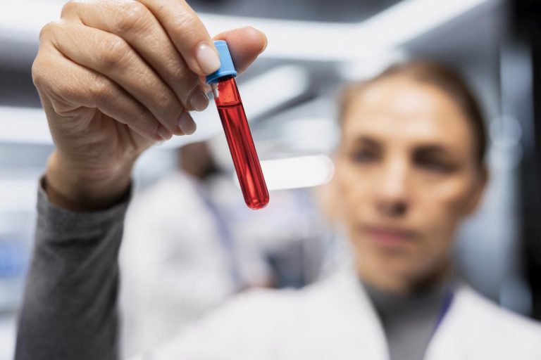 Femme médecin tenant un tube de prélèvement sanguin pour dosage de la CRP